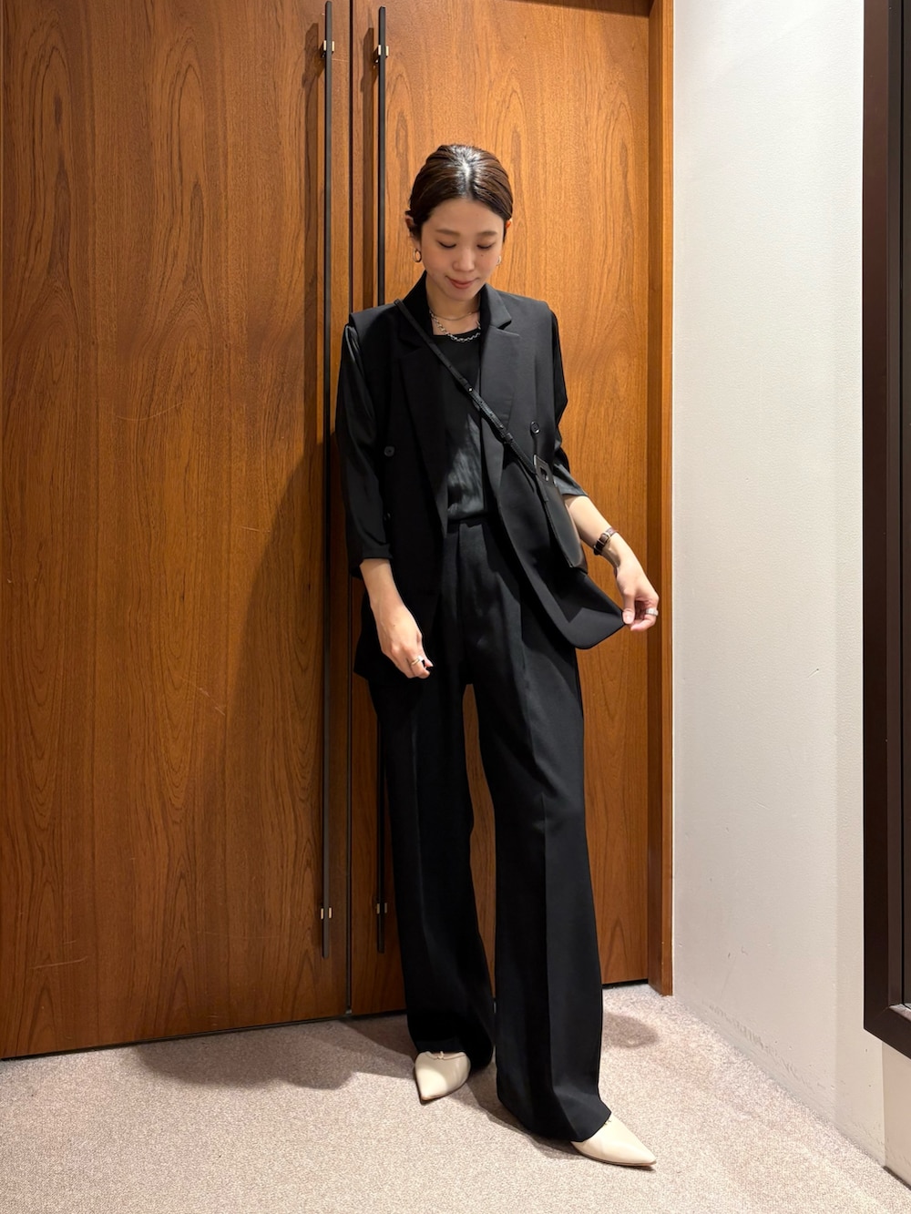 ベージュ系のトレンチコート、ブラック系のその他パンツ、ブラック系のその他アウターを着用したレディースの冬コーディネートの9枚目の写真