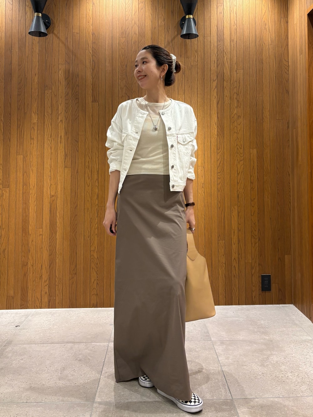 グレー系のスカート、ホワイト系のTシャツ/カットソー、ベージュ系のハンドバッグを着用したレディースの春コーディネートの5枚目の写真