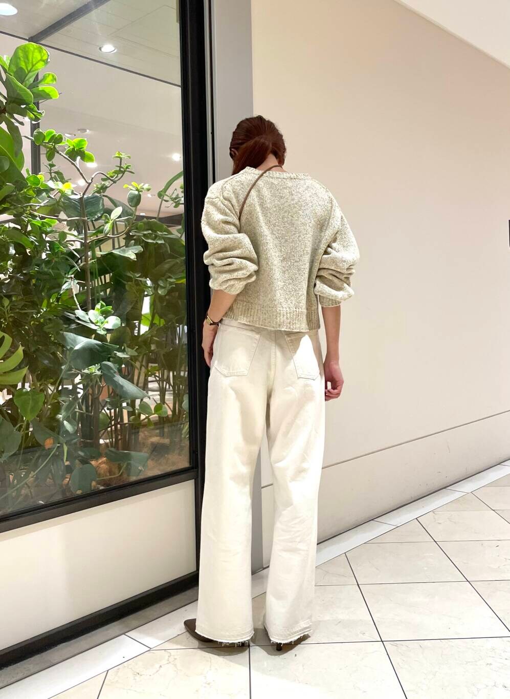 ホワイト系のデニムパンツ、ブラウン系のブーツ、ホワイト系のニット/セーターを着用したレディースの秋コーディネートの3枚目の写真