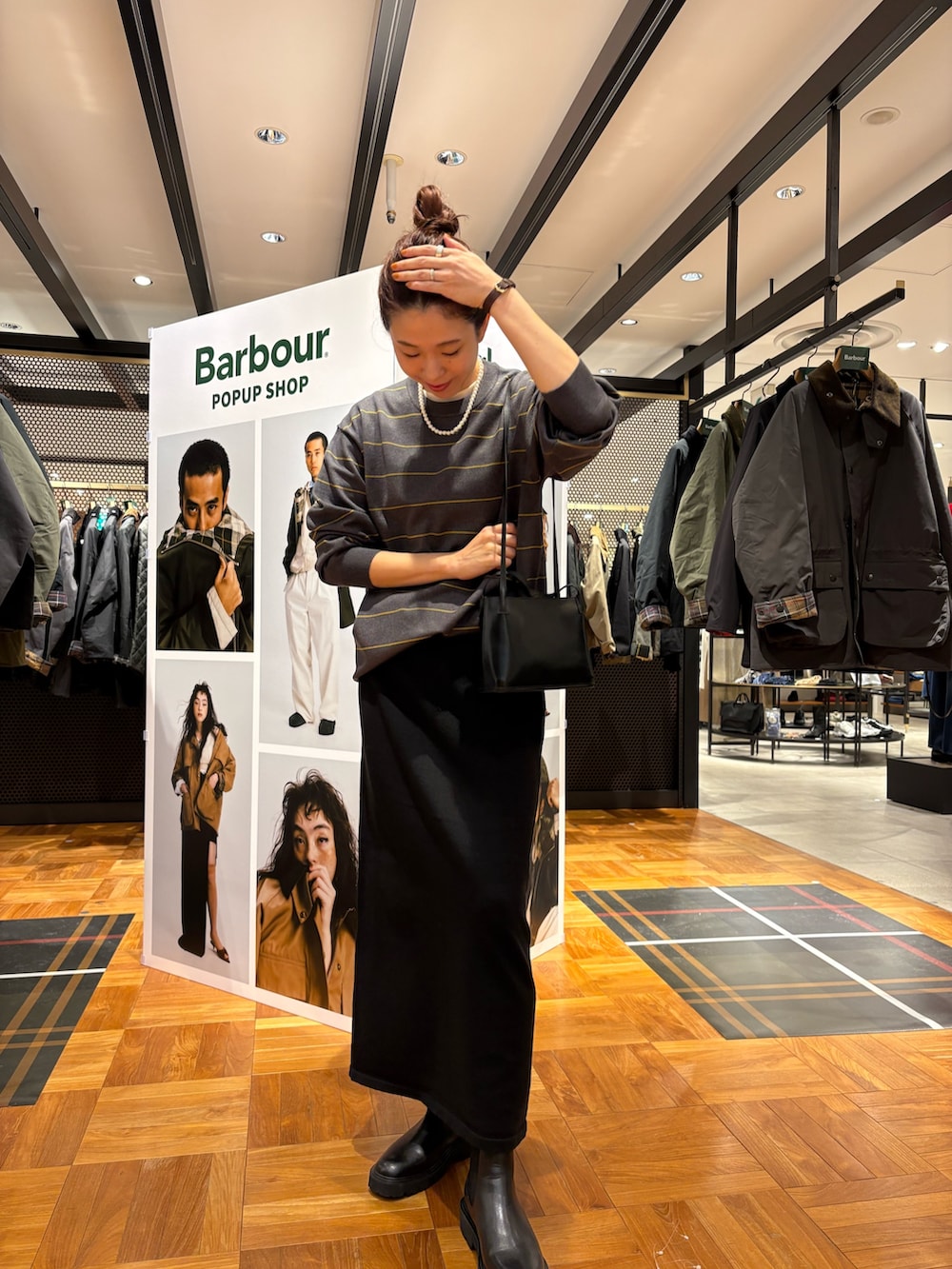 ブラック系のブーツ、ブラック系のショルダーバッグ、ブラック系のスカートを着用したレディースの秋コーディネートの5枚目の写真