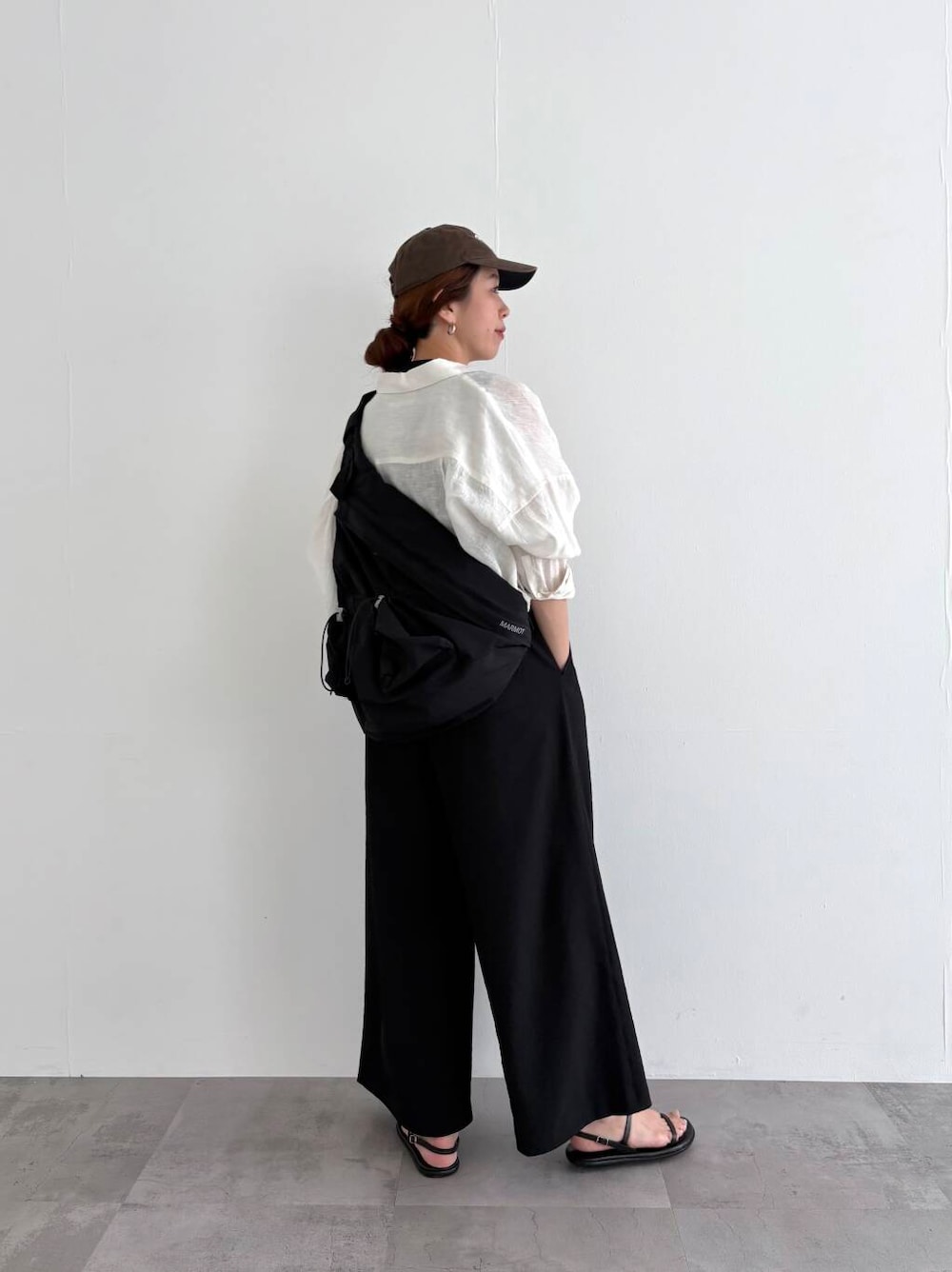 ホワイト系のシャツ/ブラウス、ブラック系のバックパック/リュック、ブラック系のサロペット/オーバーオールを着用したレディースの春コーディネートの2枚目の写真