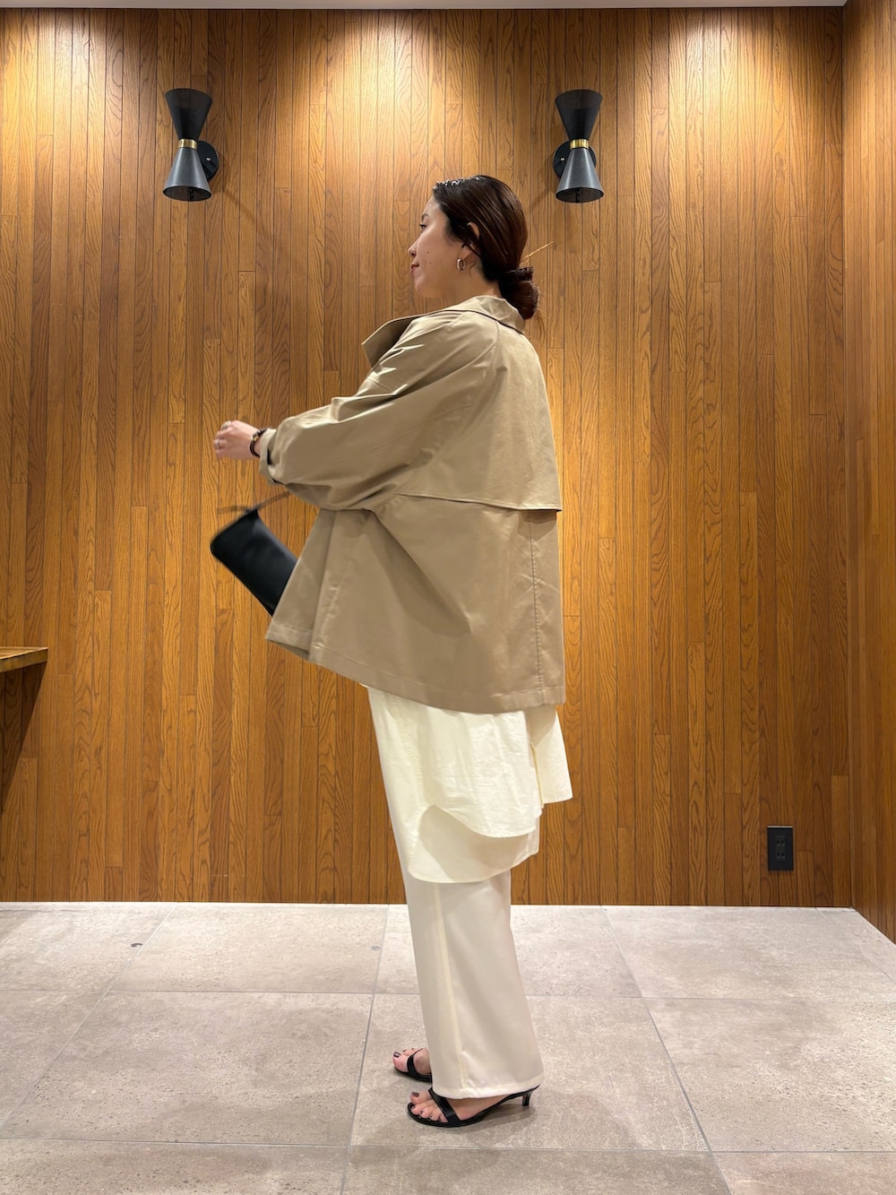 ベージュ系のトレンチコート、イエロー系のニット/セーター、ホワイト系のその他パンツを着用したレディースの春コーディネートの4枚目の写真