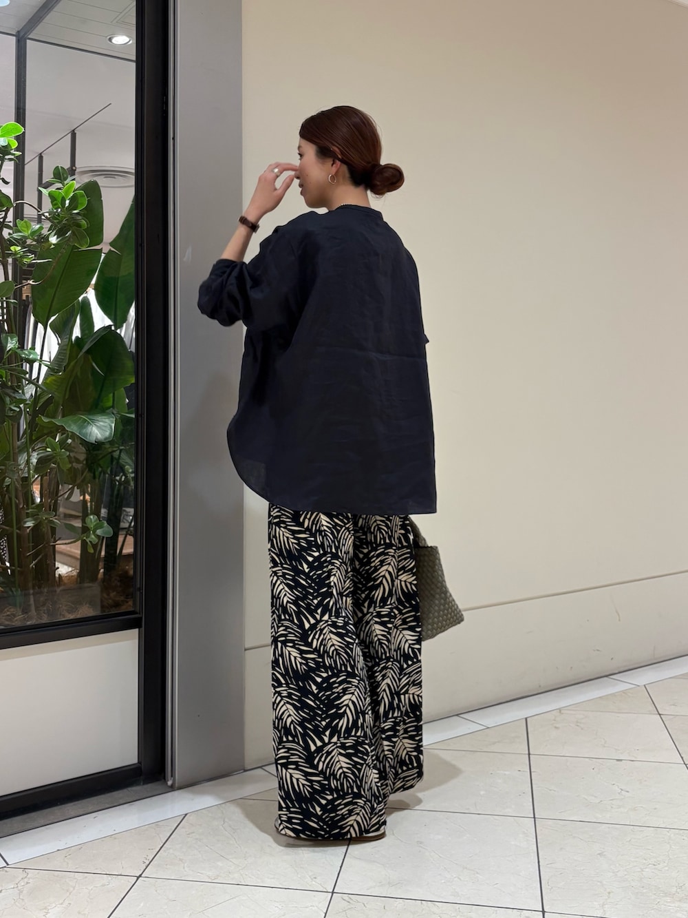 ブルー系のシャツ/ブラウス、ブラック系のその他パンツ、グリーン系のトートバッグを着用したレディースの春コーディネートの4枚目の写真