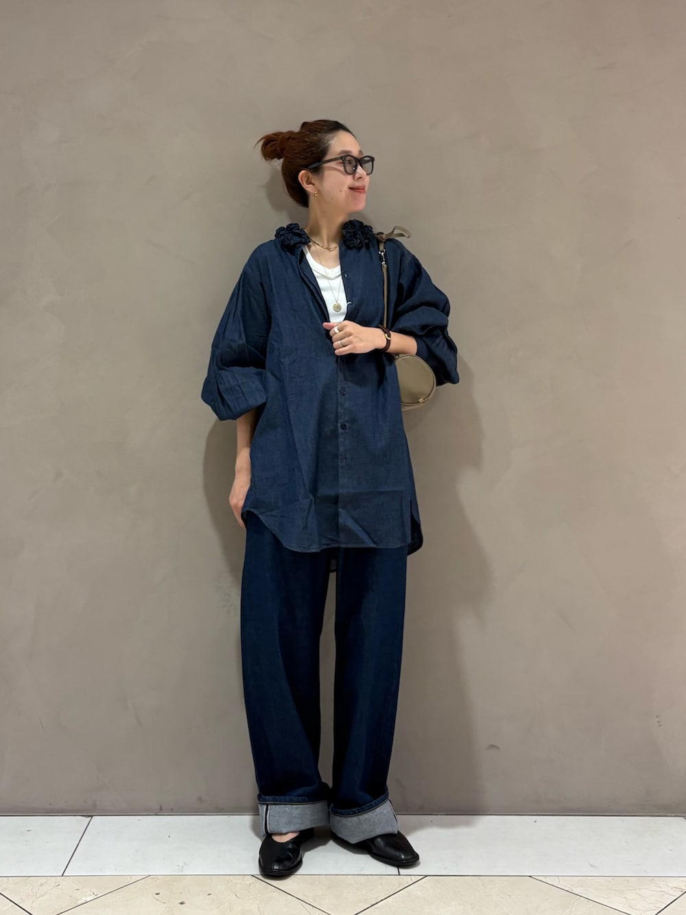 ブルー系のシャツ/ブラウス、ブルー系のデニムパンツ、ホワイト系のタンクトップを着用したレディースの秋コーディネートの6枚目の写真