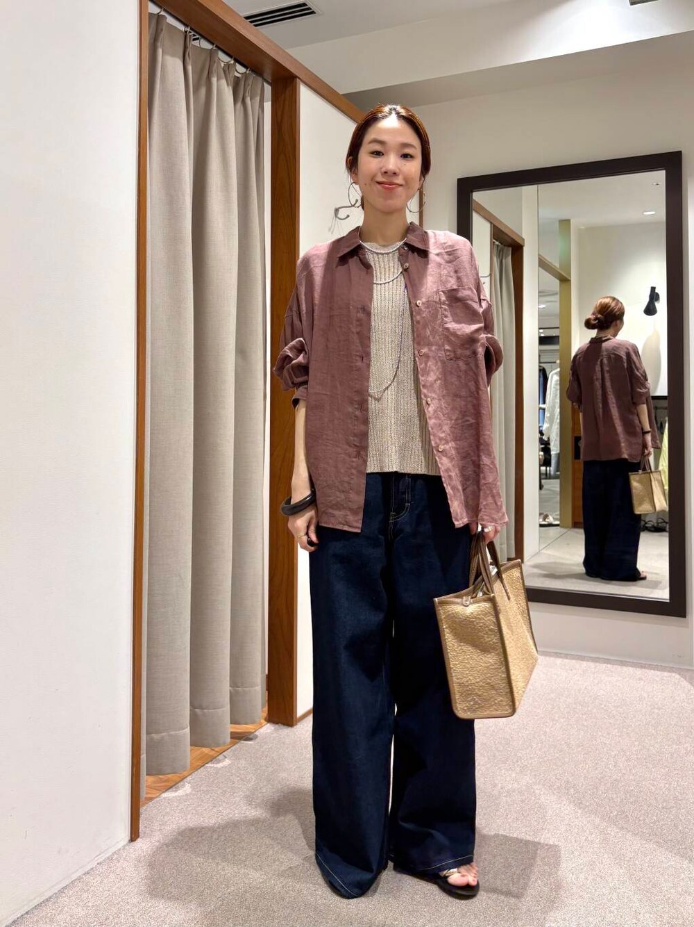 ブルー系のデニムパンツ、イエロー系のニット/セーター、ブラウン系のシャツ/ブラウスを着用したレディースの夏コーディネートの6枚目の写真