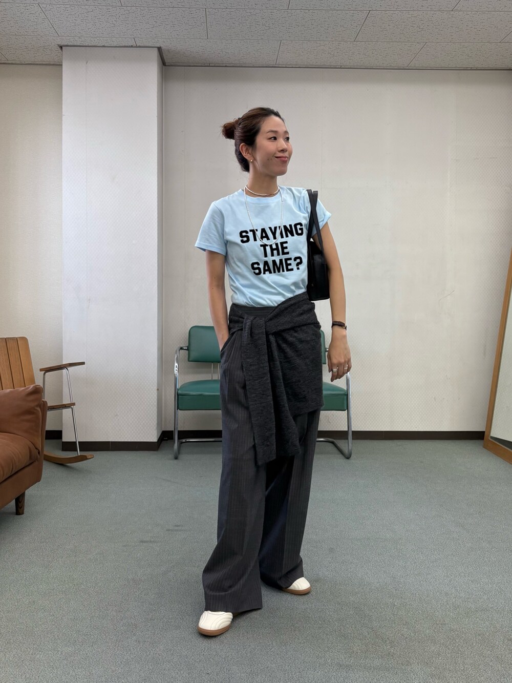グレー系のその他パンツ、ホワイト系のスニーカー、ブラック系のハンドバッグを着用したレディースの秋コーディネートの8枚目の写真