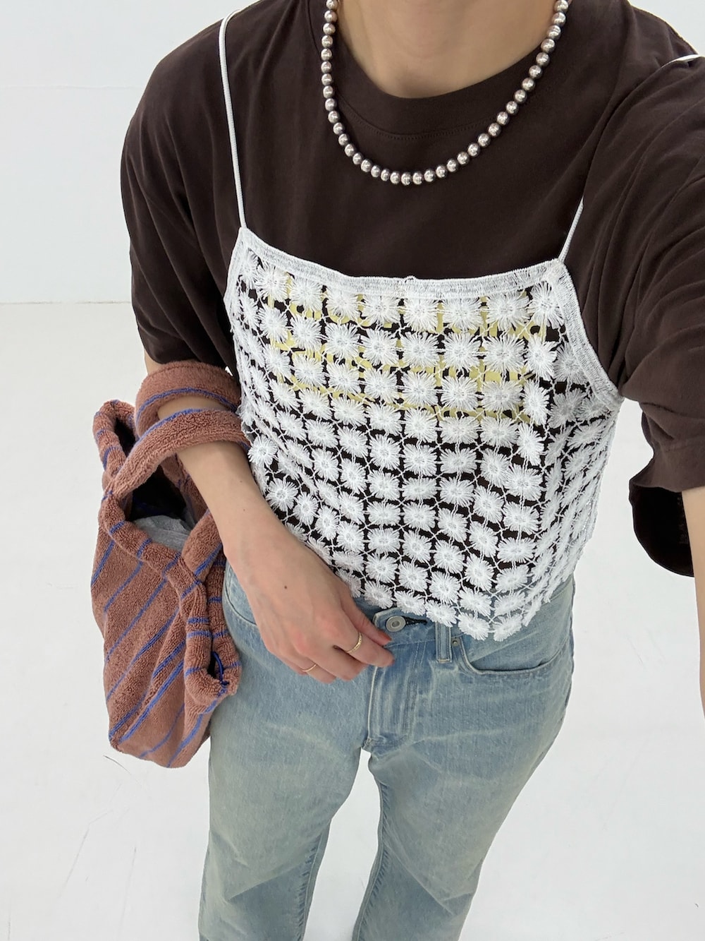 ブルー系のデニムパンツ、ホワイト系のその他トップス、イエロー系のハンドバッグを着用したレディースの春コーディネートの8枚目の写真