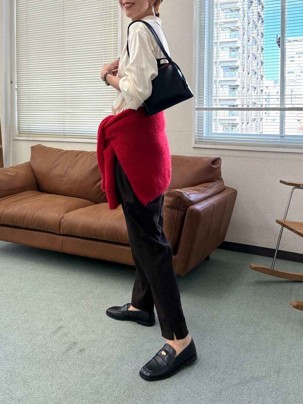 レッド系のニット/セーター、ブラウン系のその他パンツ、ブラック系のローファーを着用したレディースの秋コーディネートの6枚目の写真