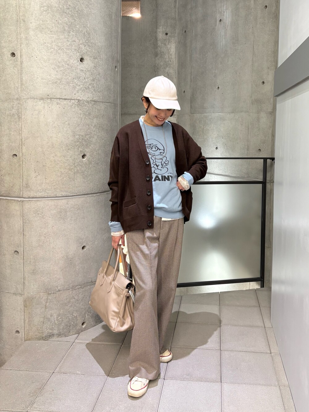 イエロー系のその他パンツ、ブルー系のTシャツ/カットソー、ベージュ系のハンドバッグを着用したレディースの秋コーディネートの4枚目の写真