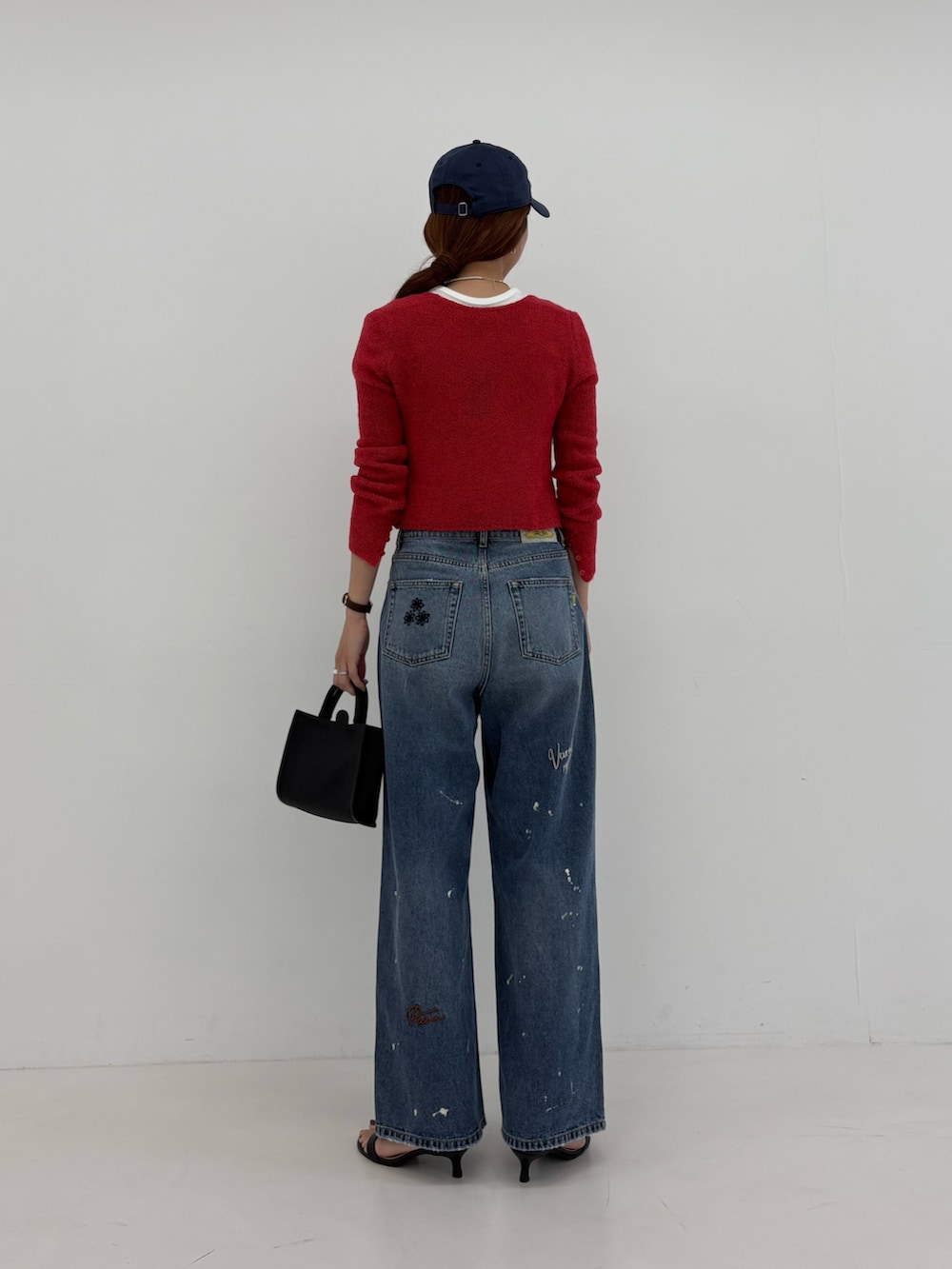 ブルー系のデニムパンツ、ホワイト系のTシャツ/カットソー、ブラック系のハンドバッグを着用したレディースの夏コーディネートの4枚目の写真