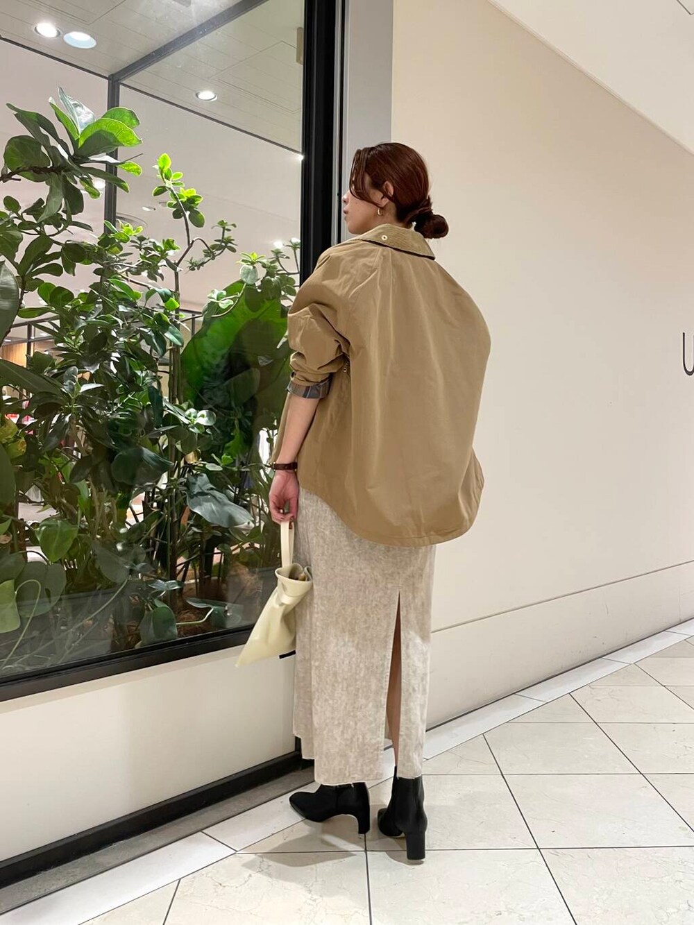 イエロー系のTシャツ/カットソー、ベージュ系のワンピース、ホワイト系のニット/セーターを着用したレディースの冬コーディネートの5枚目の写真