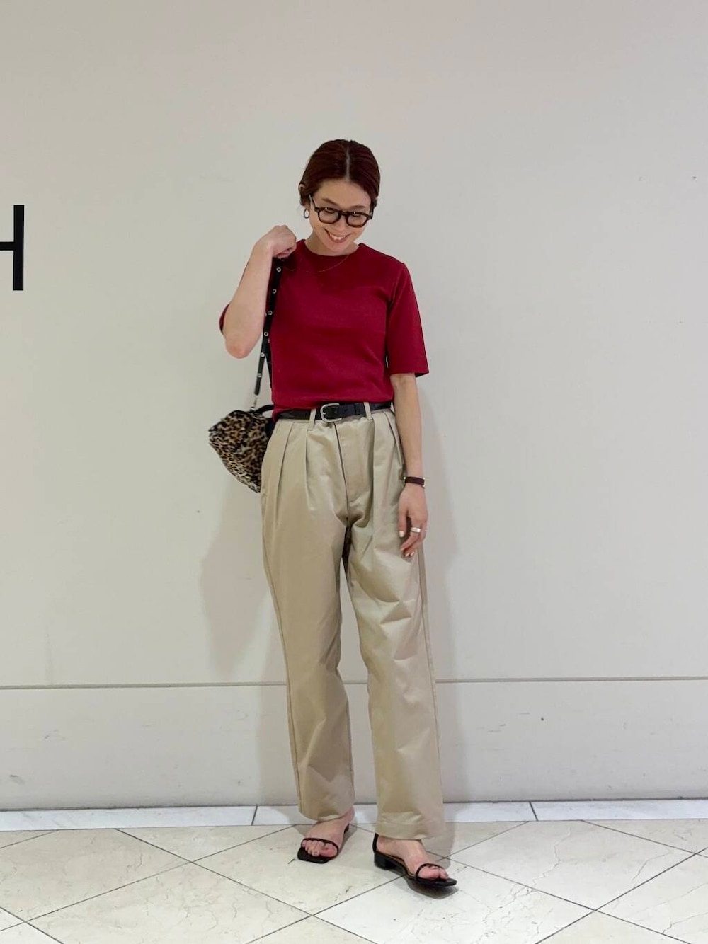 ベージュ系のチノパンツ、ブラック系のサンダル、レッド系のTシャツ/カットソーを着用したレディースの夏コーディネートの4枚目の写真