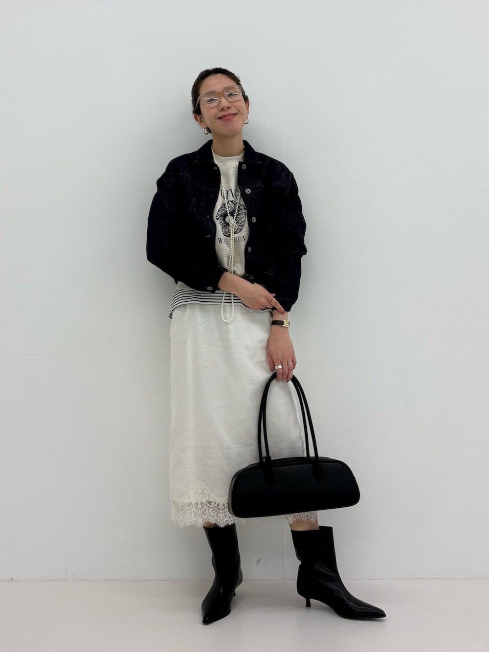 ブルー系のデニムジャケット、ベージュ系のスウェット、ブラック系のブーツを着用したレディースの冬コーディネートの6枚目の写真