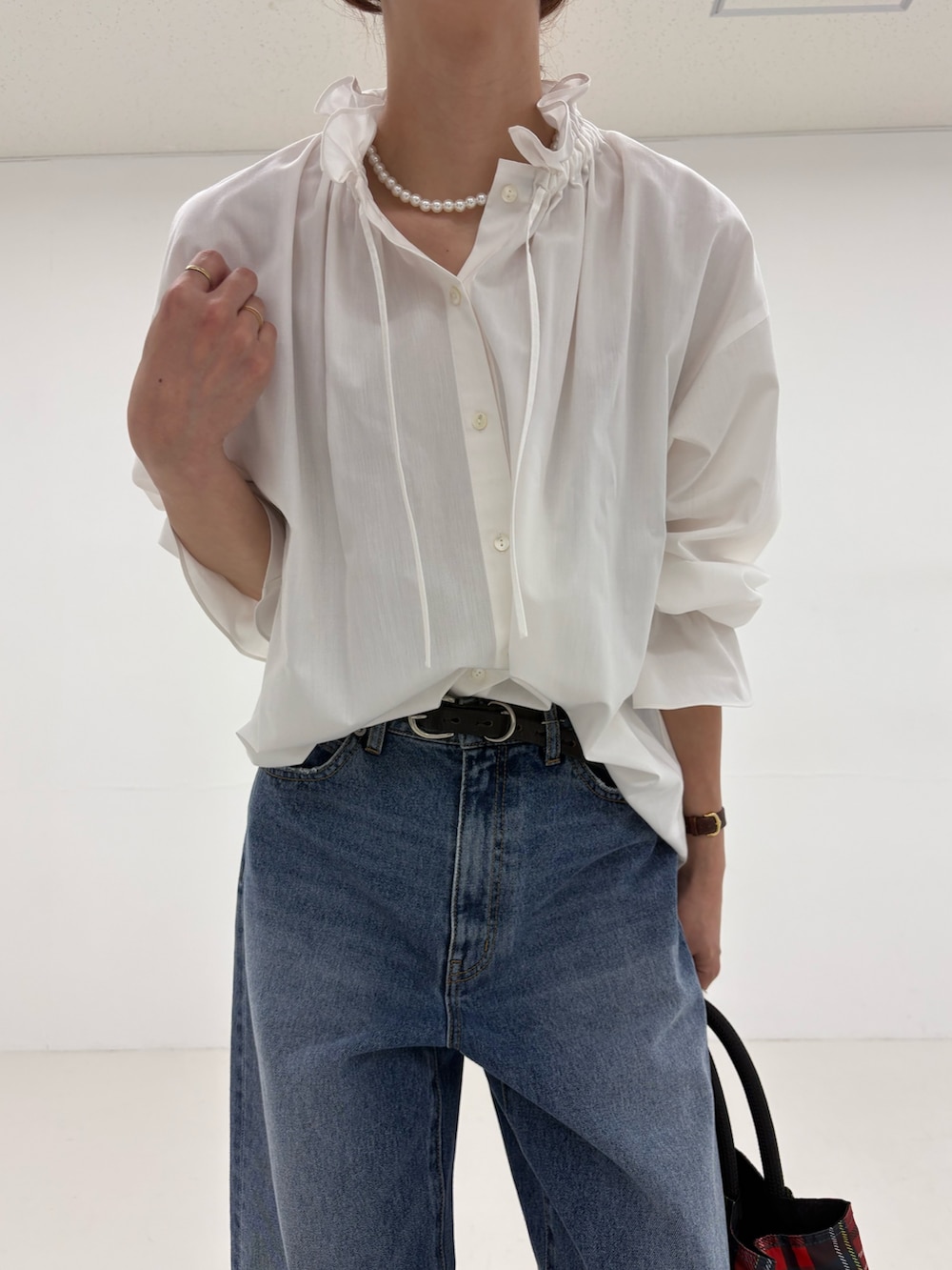 グレー系のトートバッグ、ブラック系のパンプス、ブルー系のデニムパンツを着用したレディースの夏コーディネートの6枚目の写真