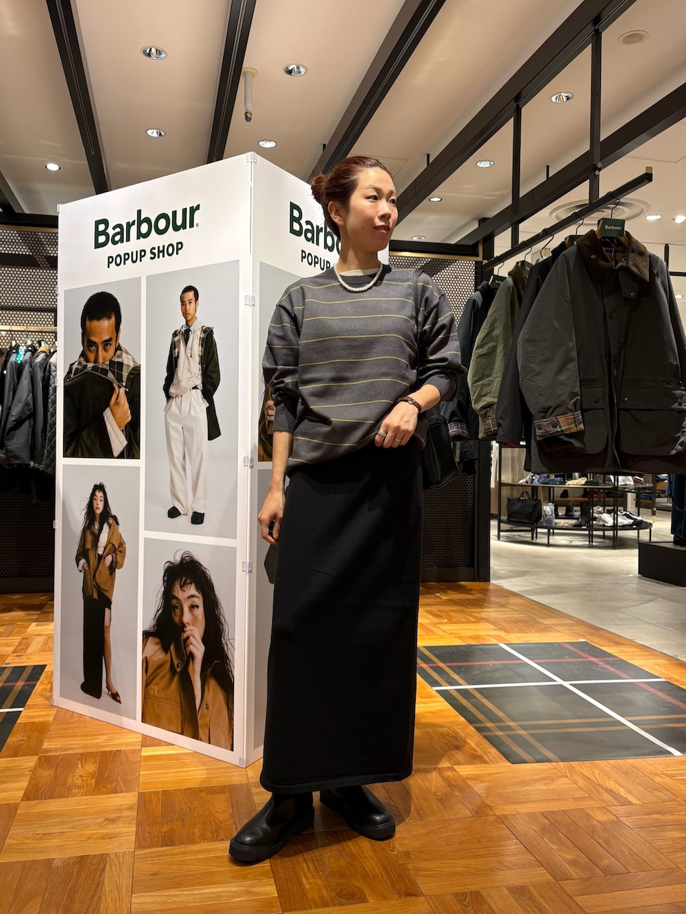 ブラック系のブーツ、ブラック系のショルダーバッグ、ブラック系のスカートを着用したレディースの秋コーディネートの3枚目の写真