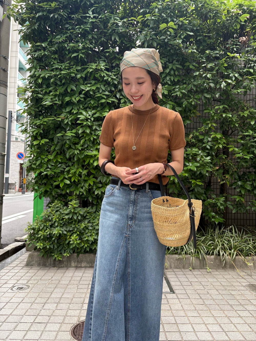 イエロー系のニット/セーター、ベージュ系のかごバッグ、ブラウン系のサンダルを着用したレディースの夏コーディネートの7枚目の写真