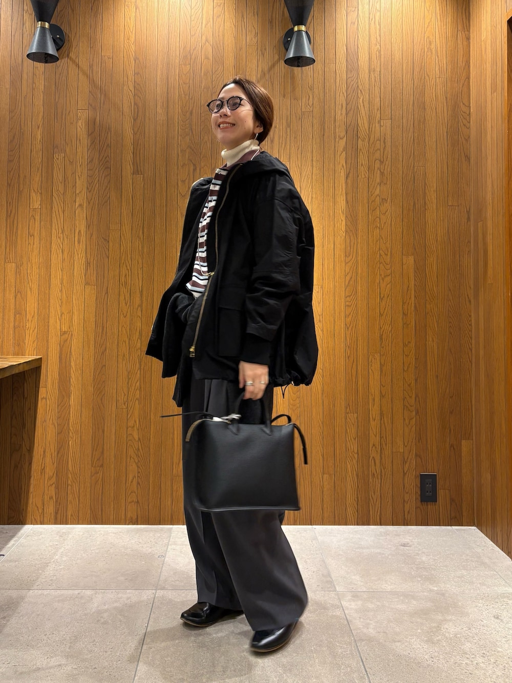 グレー系のその他パンツ、ブラック系のマウンテンパーカー、その他のポロシャツを着用したレディースの冬コーディネートの2枚目の写真