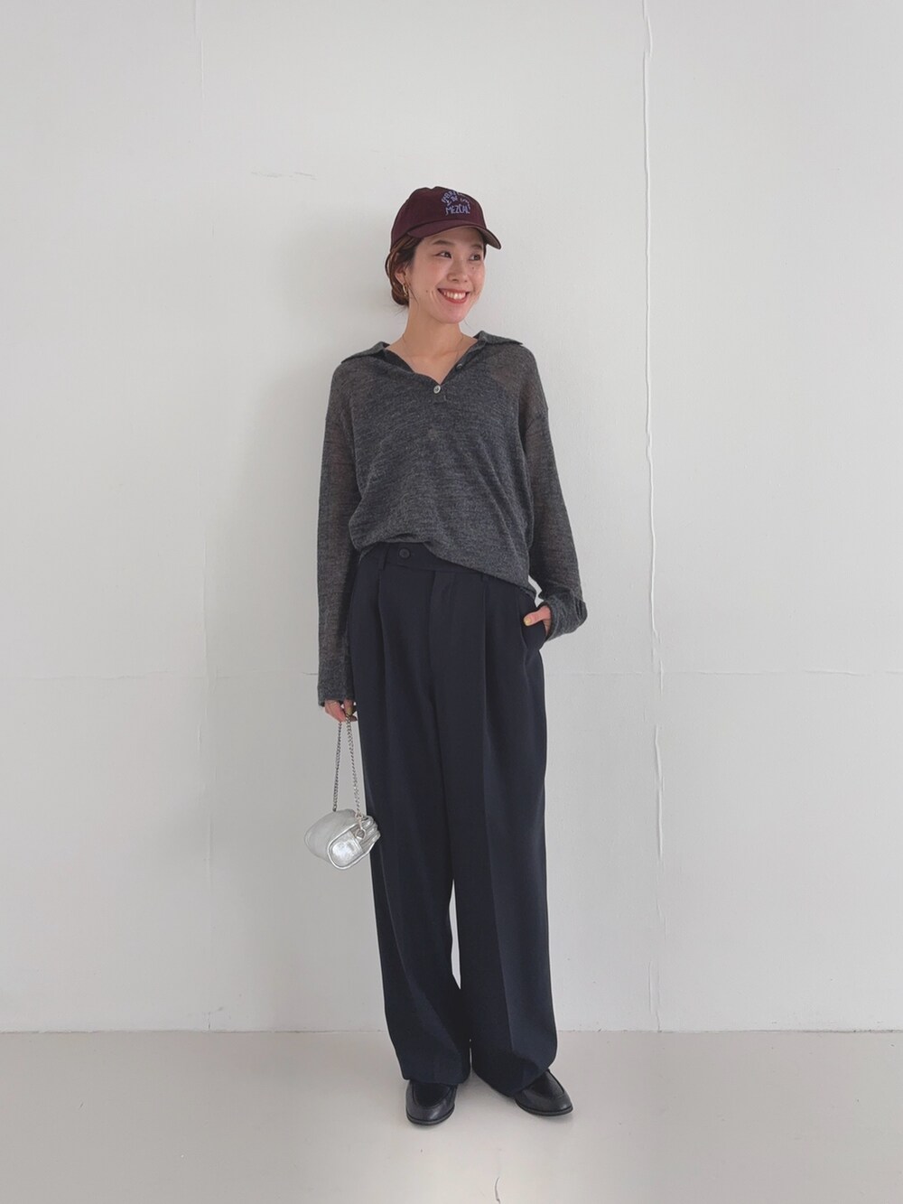 ブラック系のその他パンツ、グレー系のニット/セーター、レッド系のキャップを着用したレディースの夏コーディネートの6枚目の写真