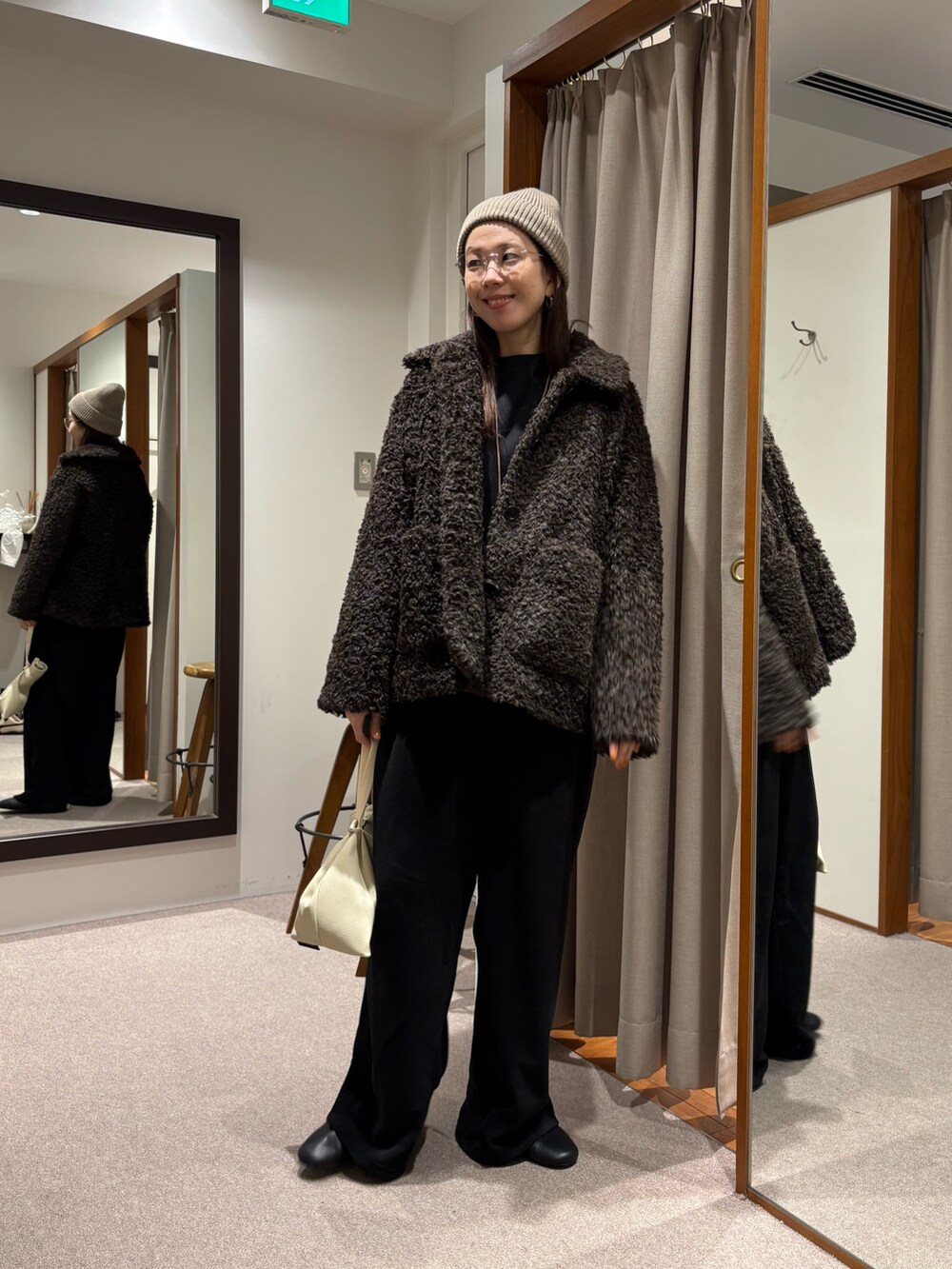 ブラウン系のその他アウター、ブラック系のその他パンツ、ブラック系のニット/セーターを着用したレディースの冬コーディネートの5枚目の写真