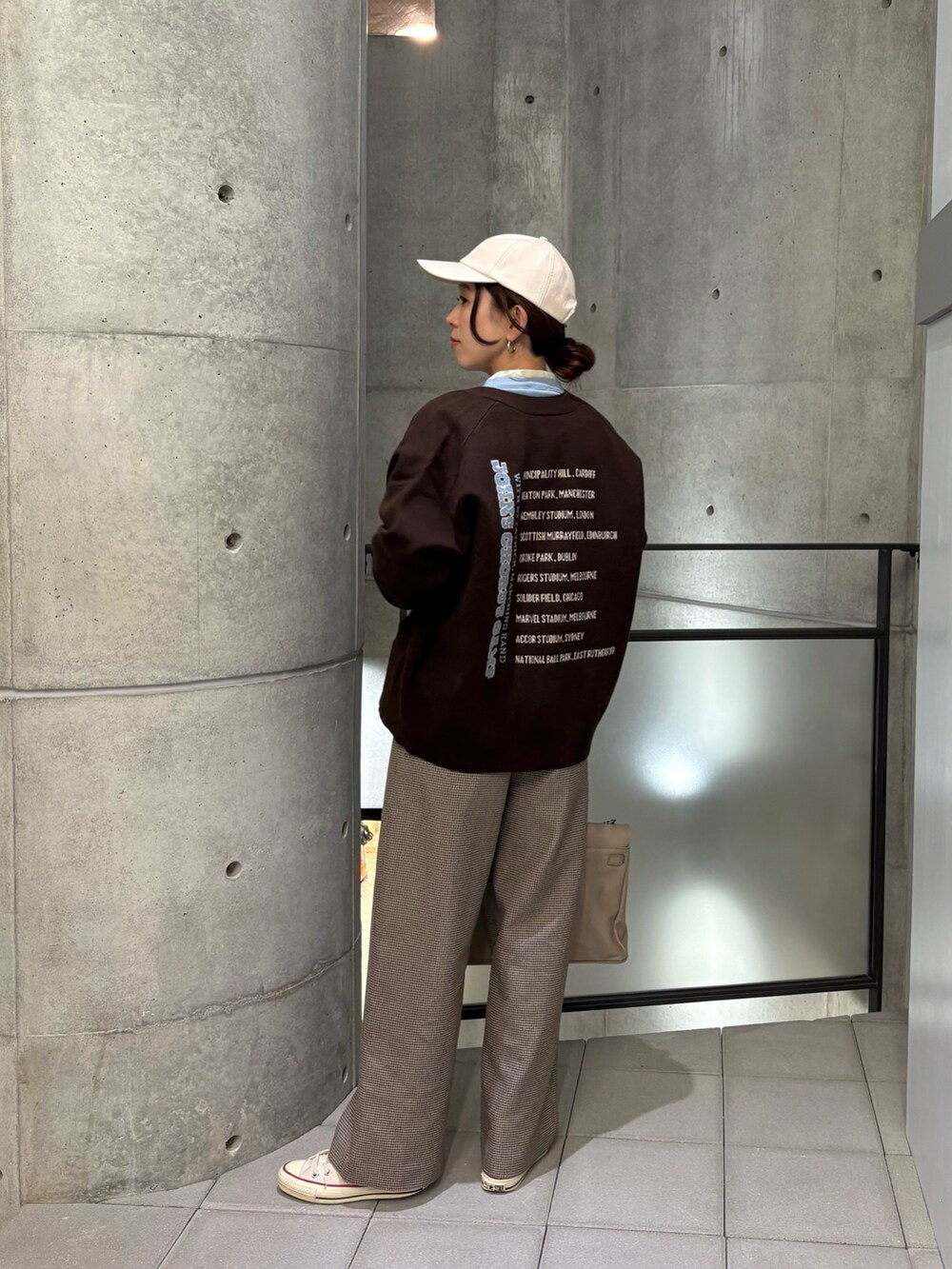 イエロー系のその他パンツ、ブルー系のTシャツ/カットソー、ベージュ系のハンドバッグを着用したレディースの秋コーディネートの5枚目の写真