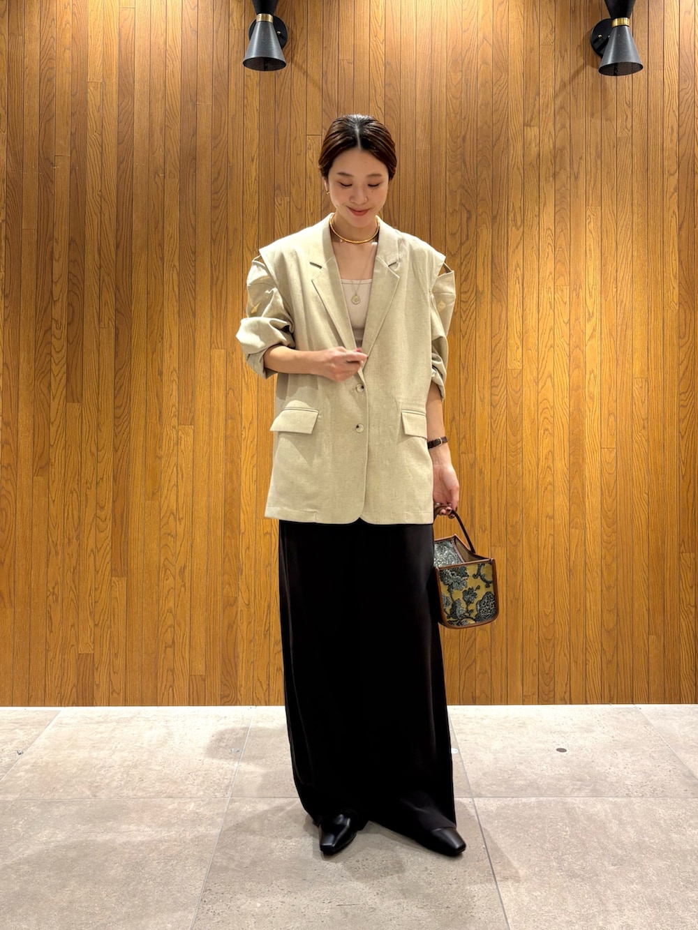 ホワイト系のその他アウター、ブラウン系のその他パンツ、ベージュ系のハンドバッグを着用したレディースの秋コーディネートの2枚目の写真