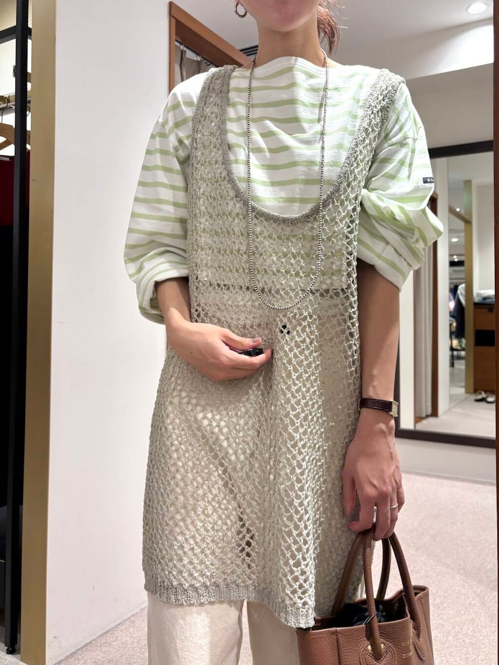 グリーン系のTシャツ/カットソー、グレー系のニット/セーター、ブラック系のサンダルを着用したレディースの夏コーディネートの6枚目の写真