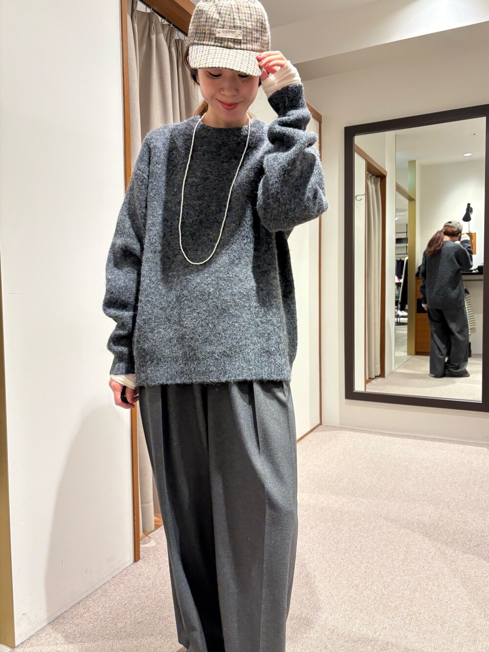 ブラック系のチェスターコート、グレー系のその他パンツ、ブラック系のハンドバッグを着用したレディースの冬コーディネートの7枚目の写真