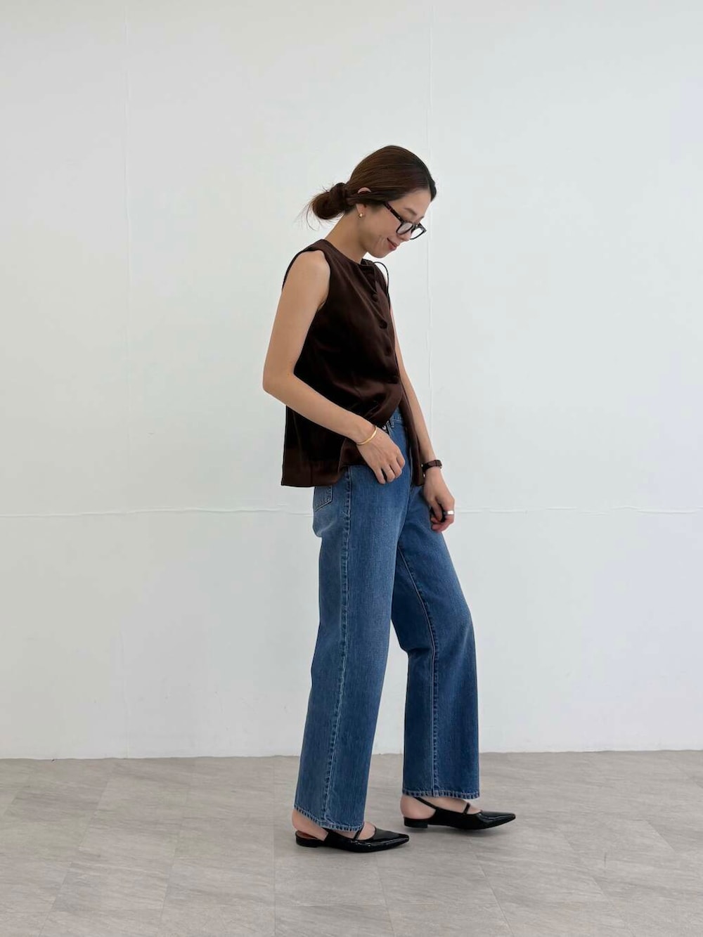 ブラック系のショルダーバッグ、ブラック系のパンプス、ブルー系のデニムパンツを着用したレディースの夏コーディネートの3枚目の写真