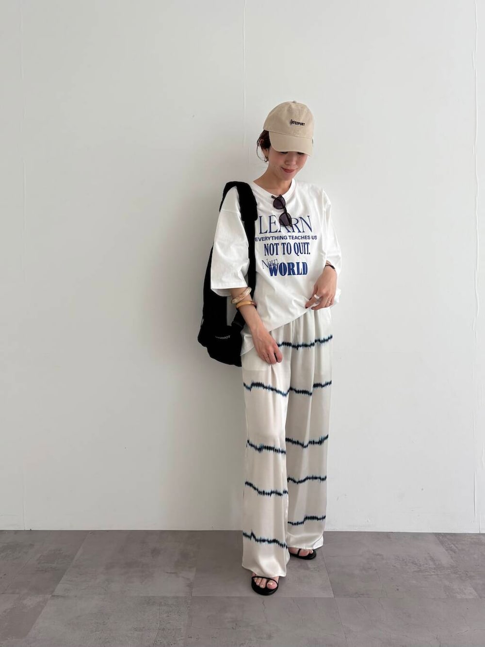 ブラック系のバックパック/リュック、その他のTシャツ/カットソー、ブラック系のサンダルを着用したレディースの春コーディネートの6枚目の写真