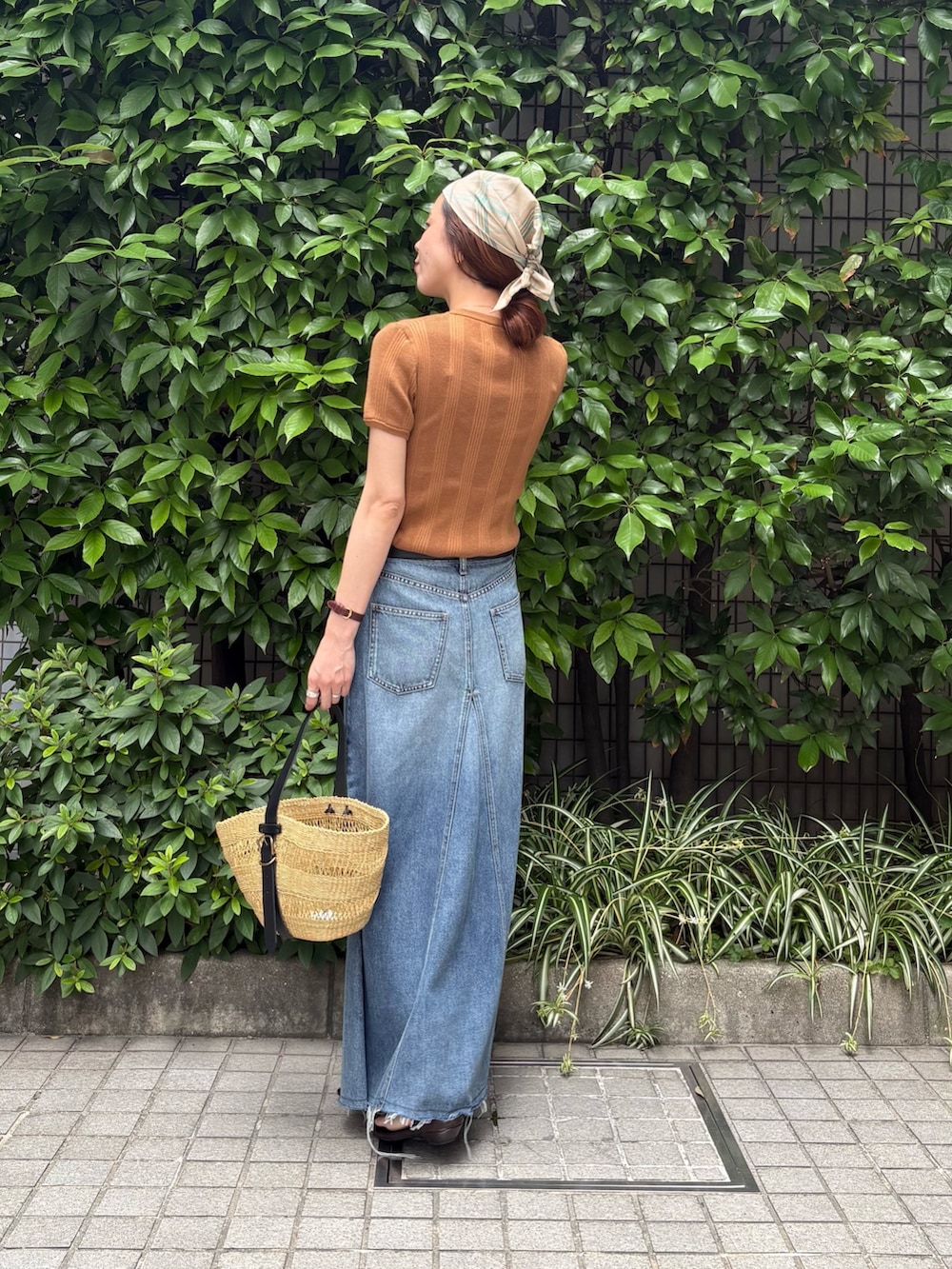 イエロー系のニット/セーター、ベージュ系のかごバッグ、ブラウン系のサンダルを着用したレディースの夏コーディネートの3枚目の写真