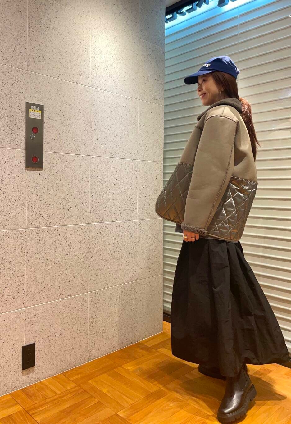 グレー系のその他アウター、ブラック系のブーツ、ブラック系のスカートを着用したレディースの冬コーディネートの3枚目の写真