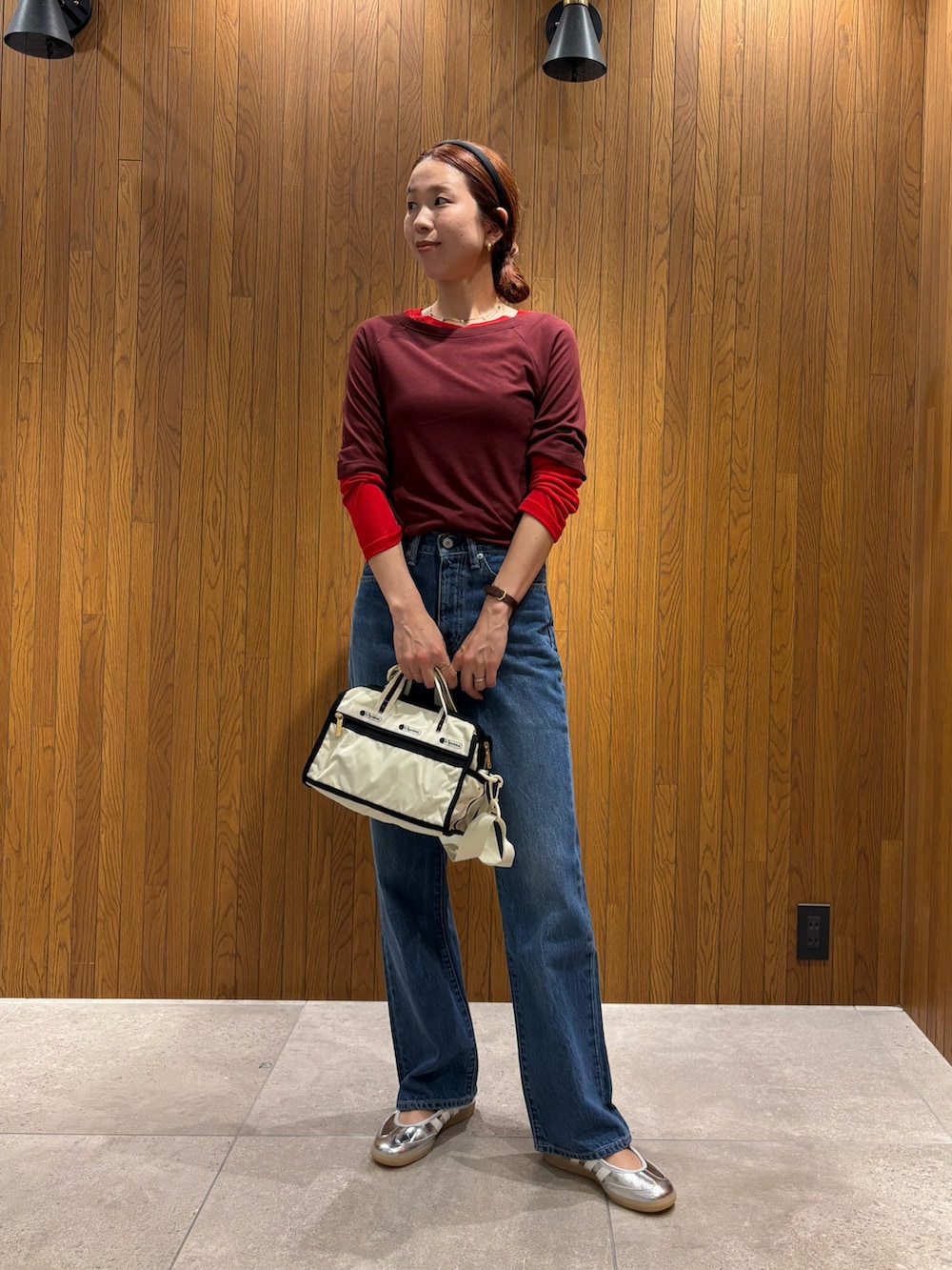 レッド系のTシャツ/カットソー、ブルー系のデニムパンツ、シルバー系のスニーカーを着用したレディースの夏コーディネートの4枚目の写真