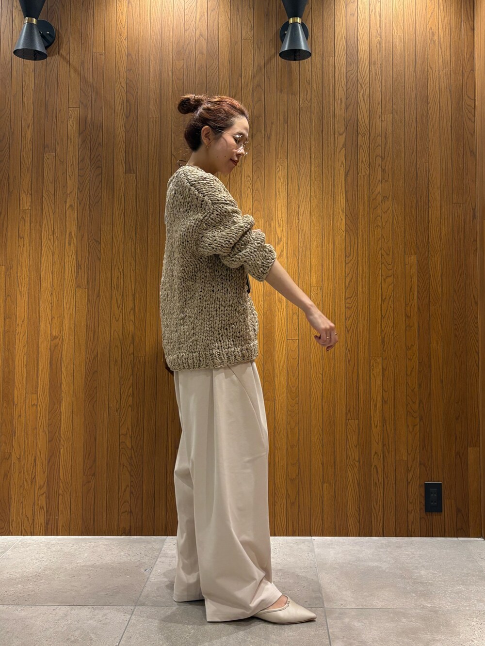グレー系のニット/セーター、ホワイト系のその他パンツ、ブラウン系のトートバッグを着用したレディースの秋コーディネートの4枚目の写真