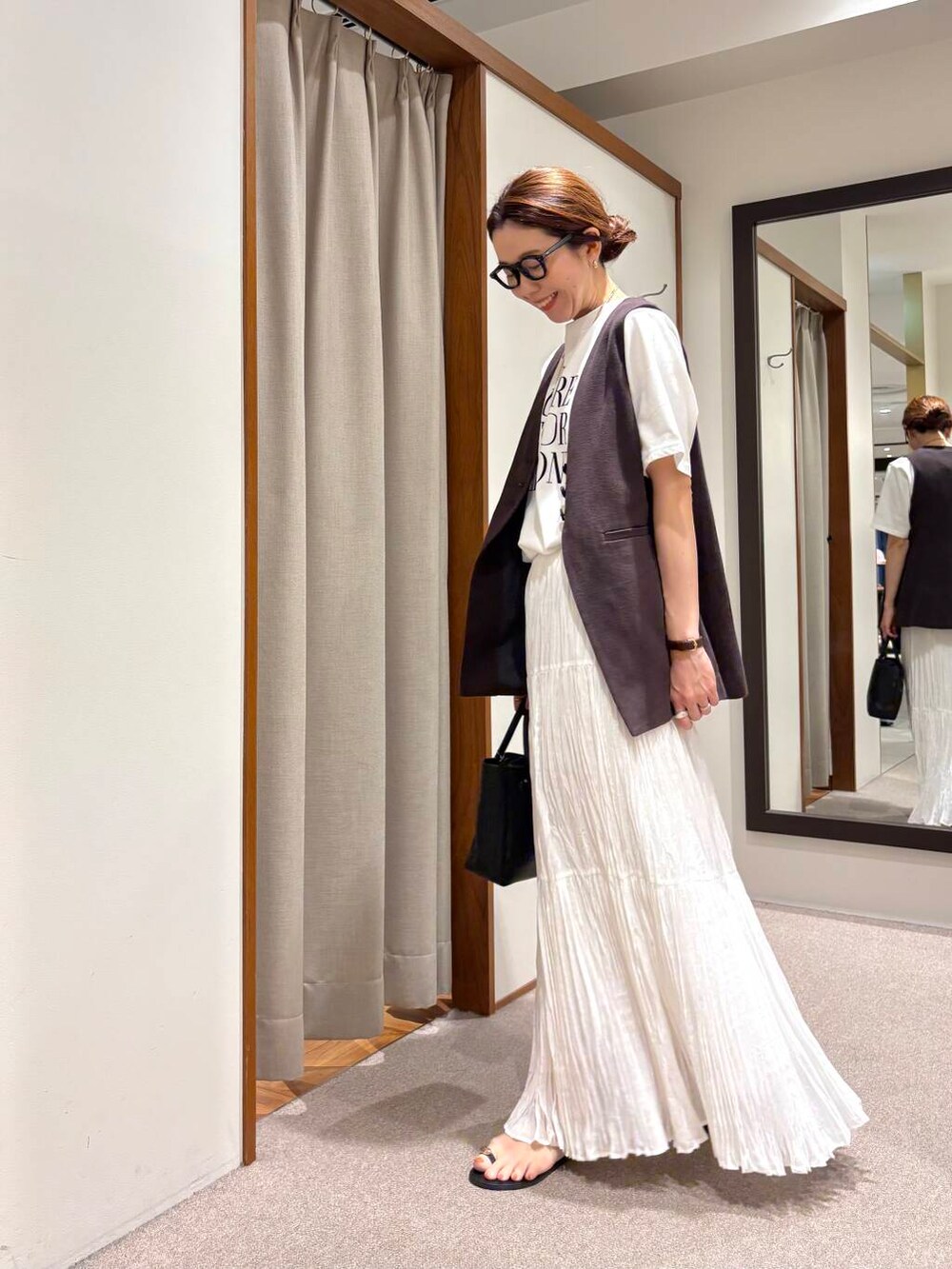 その他のTシャツ/カットソー、ホワイト系のスカート、ブラウン系のベストを着用したレディースの夏コーディネートの2枚目の写真