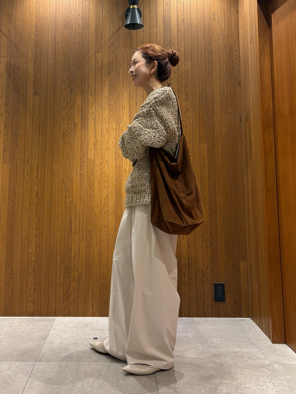 グレー系のニット/セーター、ホワイト系のその他パンツ、ブラウン系のトートバッグを着用したレディースの秋コーディネートの2枚目の写真