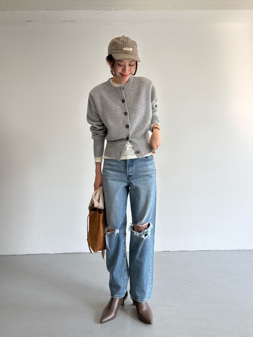 ブルー系のデニムパンツ、ベージュ系のトートバッグ、ホワイト系のTシャツ/カットソーを着用したレディースの冬コーディネートの8枚目の写真