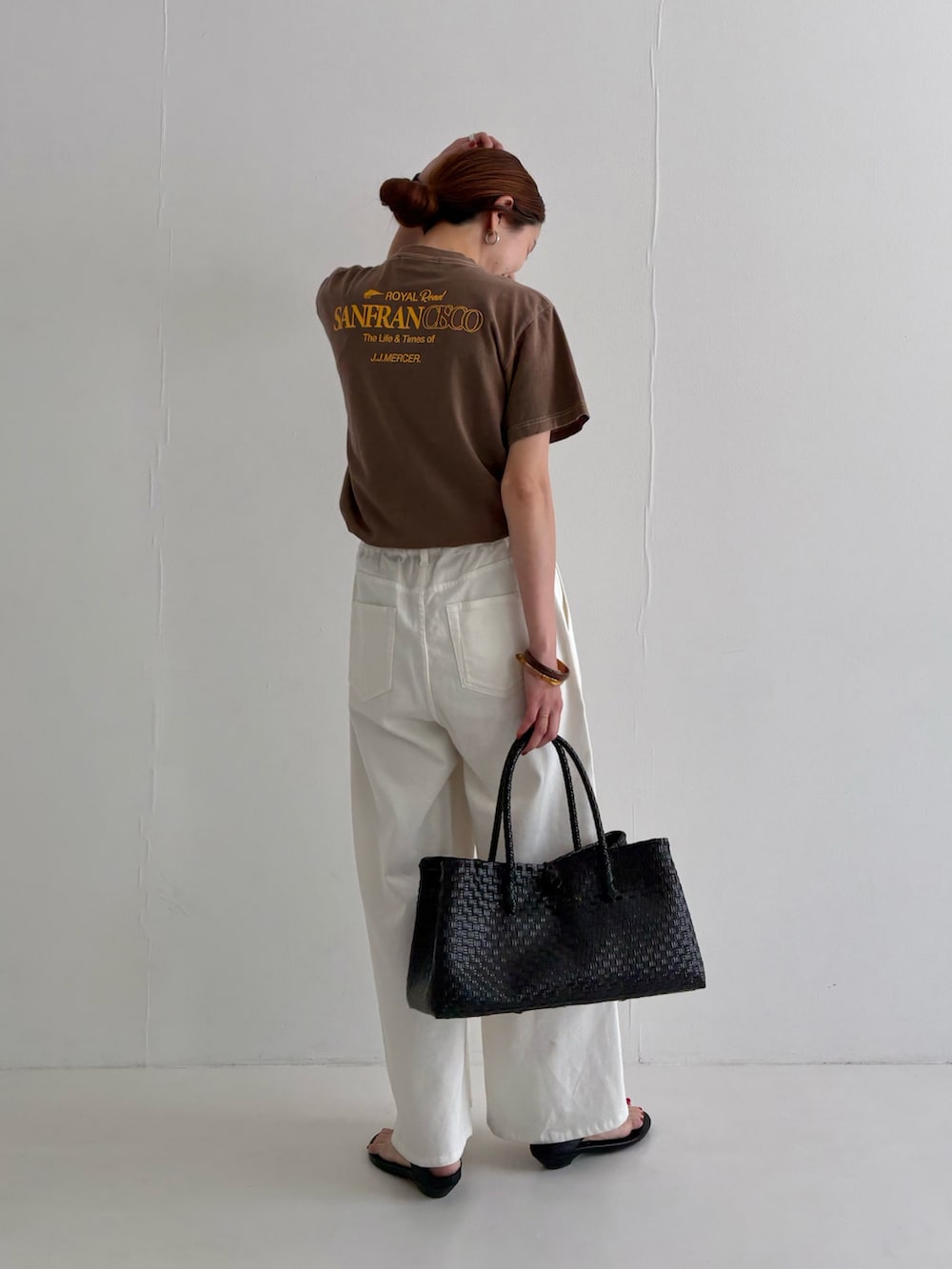 ホワイト系のデニムパンツ、ブラウン系のTシャツ/カットソー、ブラック系のサンダルを着用したレディースの春コーディネートの3枚目の写真