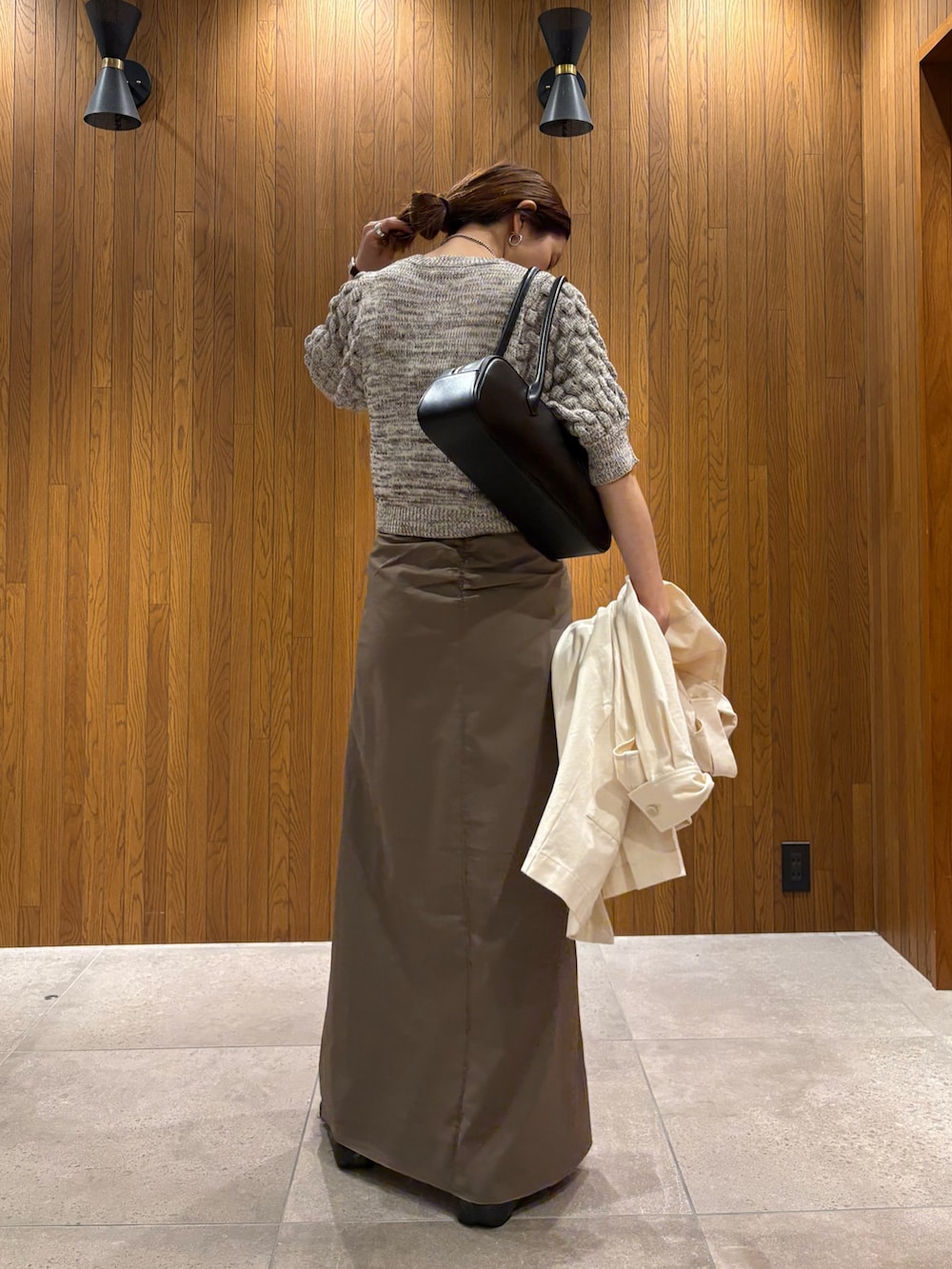 グレー系のスカート、その他のニット/セーター、ブラック系のスニーカーを着用したレディースの春コーディネートの7枚目の写真