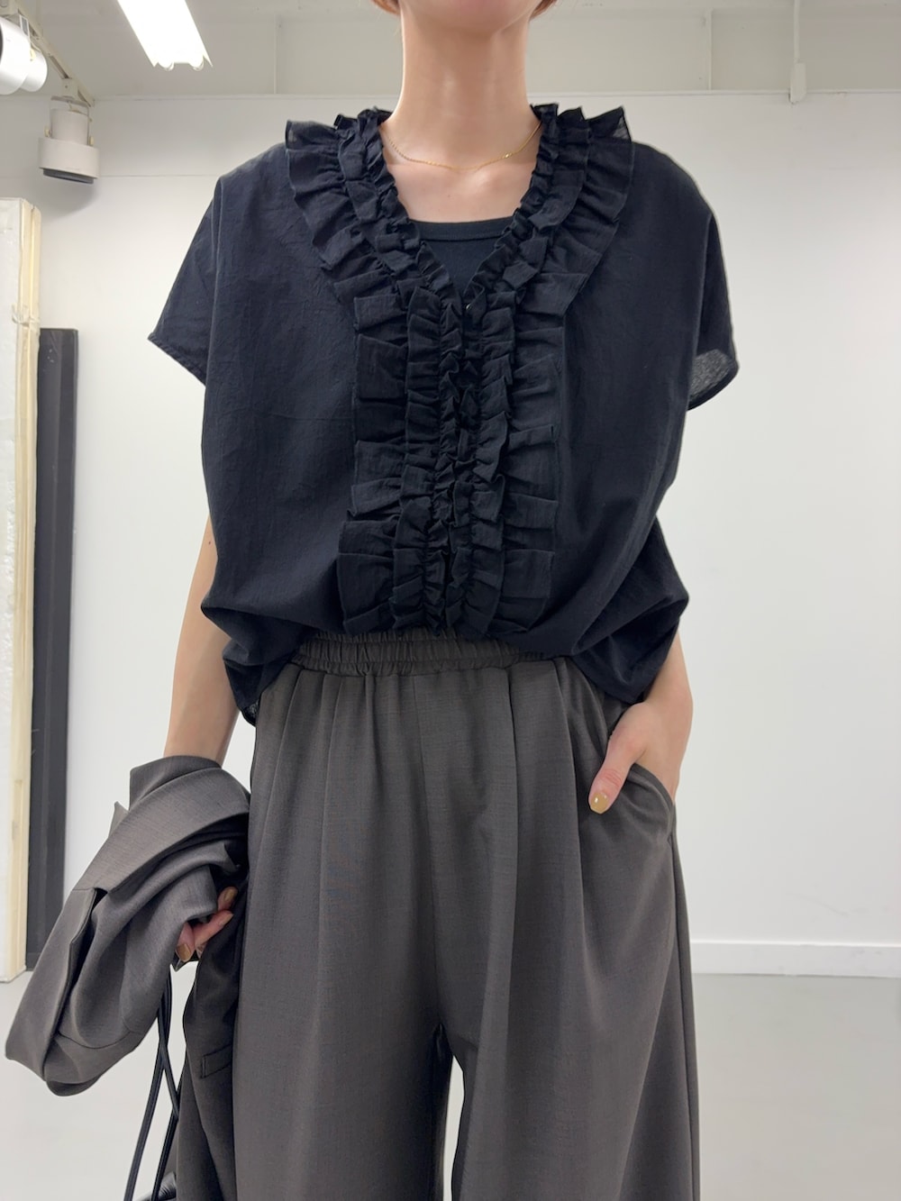 ブラック系のシャツ/ブラウス、ブラック系のショルダーバッグ、ブラック系のサンダルを着用したレディースの春コーディネートの7枚目の写真