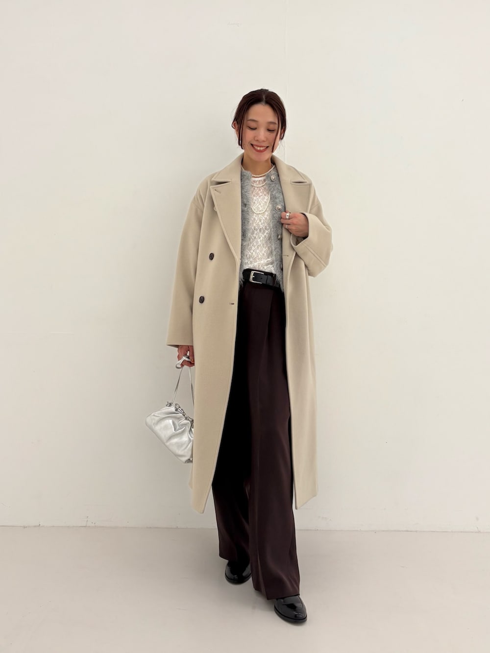 ブラウン系のその他パンツ、グリーン系のカーディガン/ボレロ、シルバー系のショルダーバッグを着用したレディースの秋コーディネートの6枚目の写真