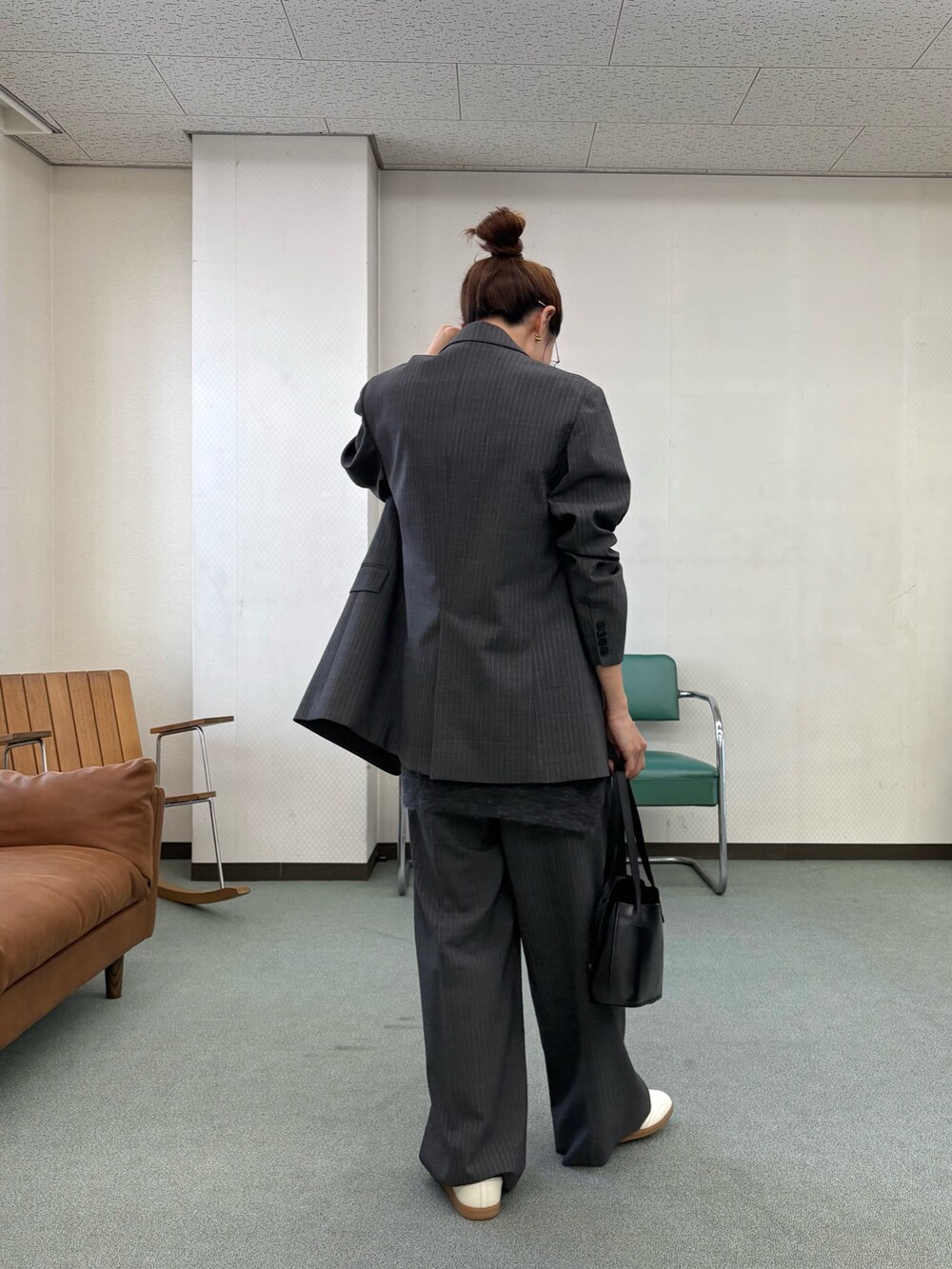 グレー系のその他パンツ、ホワイト系のスニーカー、ブラック系のハンドバッグを着用したレディースの秋コーディネートの4枚目の写真