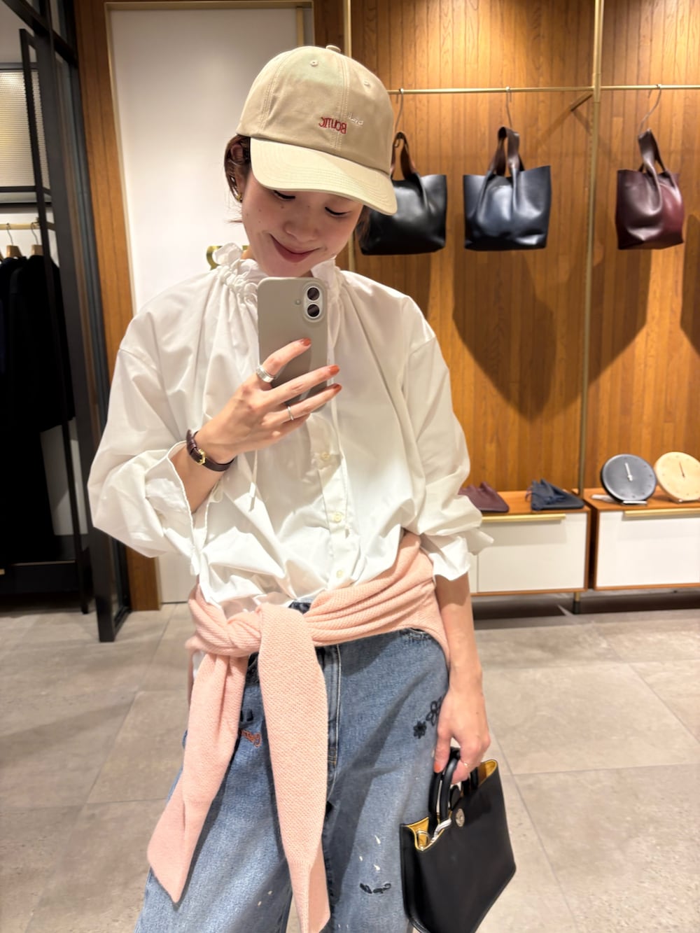 ブルー系のデニムパンツ、ベージュ系のダウンジャケット/コート、ホワイト系のシャツ/ブラウスを着用したレディースの秋コーディネートの7枚目の写真