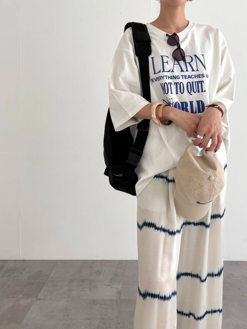 ブラック系のバックパック/リュック、その他のTシャツ/カットソー、ブラック系のサンダルを着用したレディースの春コーディネートの2枚目の写真