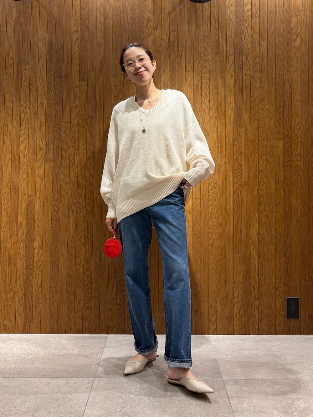ベージュ系のニット/セーター、ホワイト系のTシャツ/カットソー、レッド系のハンドバッグを着用したレディースの秋コーディネートの5枚目の写真