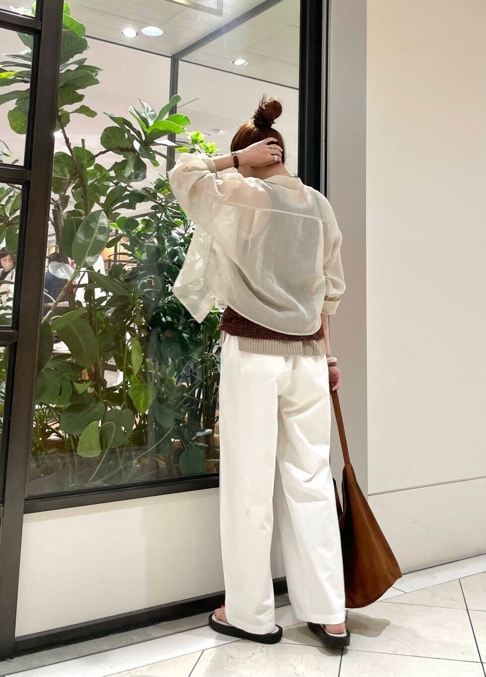 イエロー系のニット/セーター、ホワイト系のその他パンツ、ブラウン系のキャミソールを着用したレディースの春コーディネートの4枚目の写真