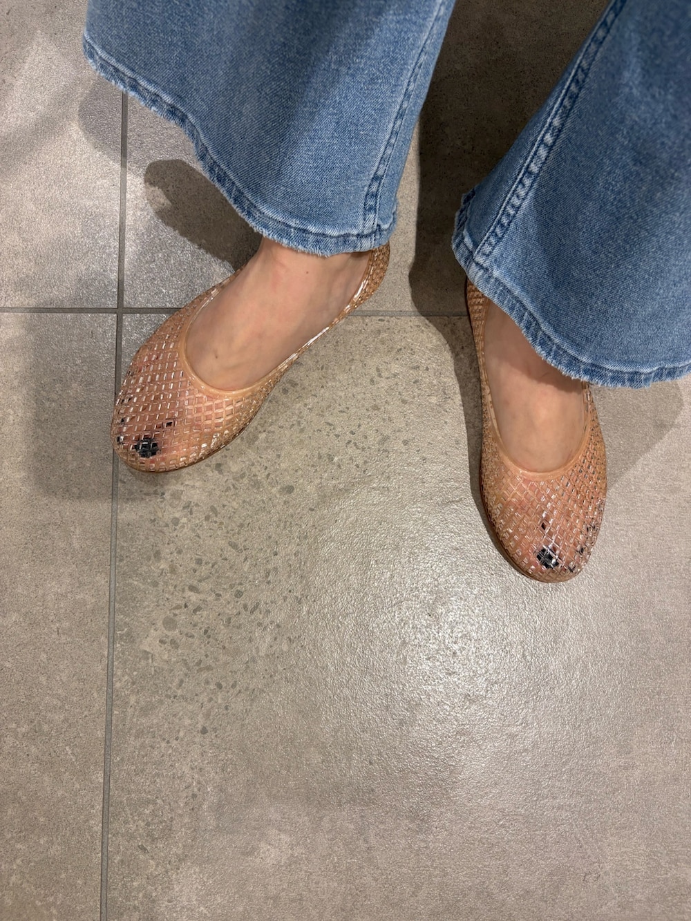 ブルー系のデニムパンツ、ホワイト系のベスト、ベージュ系のかごバッグを着用したレディースの夏コーディネートの7枚目の写真