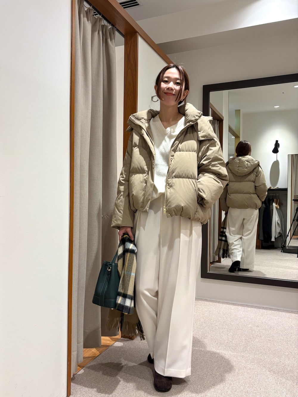 ベージュ系のダウンジャケット/コート、グリーン系のニット/セーター、ホワイト系のその他パンツを着用したレディースの秋コーディネートの2枚目の写真