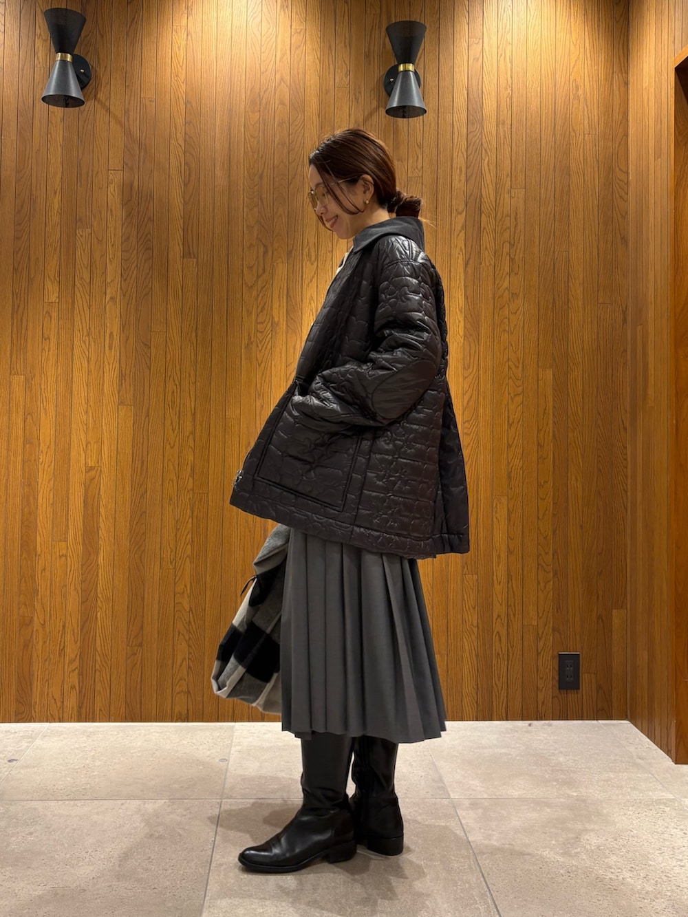 グレー系のダウンジャケット/コート、グリーン系のスカート、ブラック系のショルダーバッグを着用したレディースの冬コーディネートの4枚目の写真