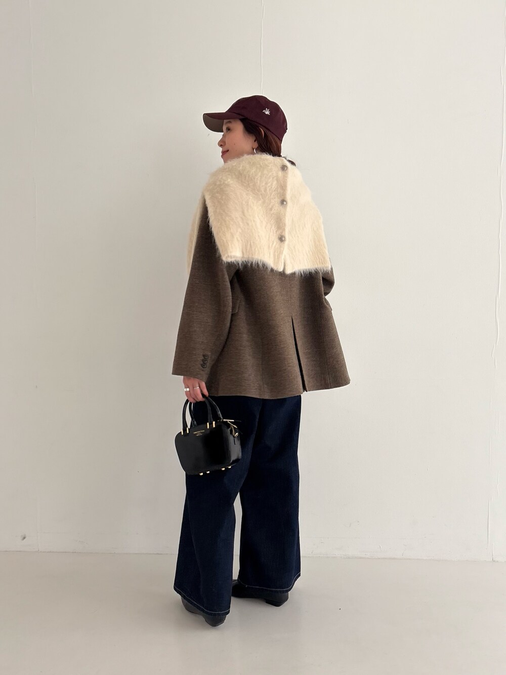 ブルー系のデニムパンツ、ブラック系のローファー、ブラック系のショルダーバッグを着用したレディースの秋コーディネートの4枚目の写真