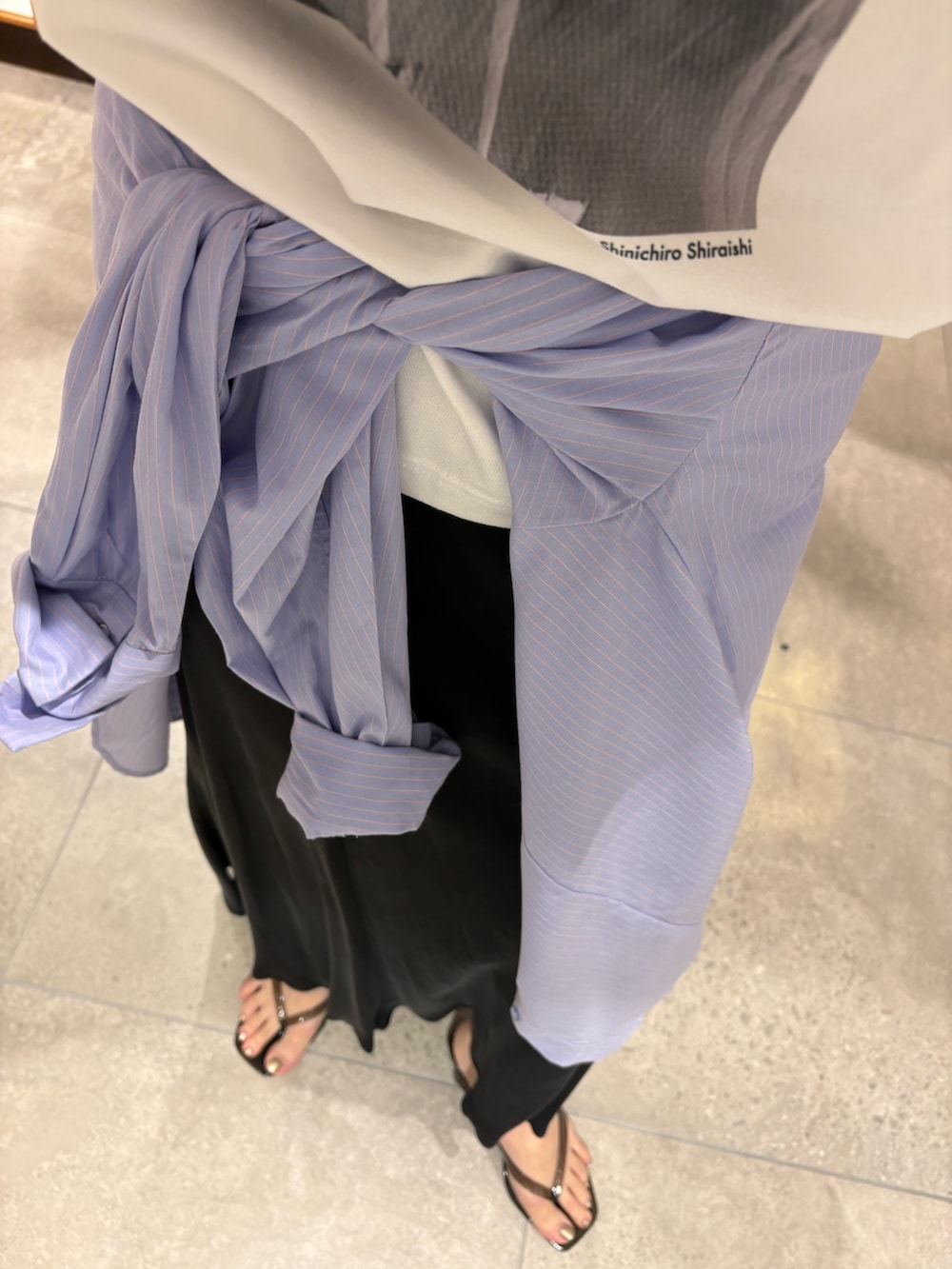 ブラック系のスカート、ブラック系のサンダル、その他のTシャツ/カットソーを着用したレディースの夏コーディネートの8枚目の写真